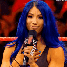 a woman with blue hair holds a microphone that says boss