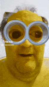 a man with yellow paint on his face is wearing a pair of minions glasses