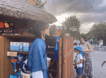 a man in a blue shirt is standing in front of a shelf with boxes of disney toys on it