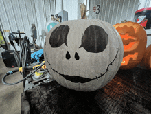 a jack skellington pumpkin sits on a table in front of a b3 sign