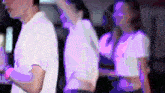 a man in a white shirt is standing in front of a woman in a purple shirt