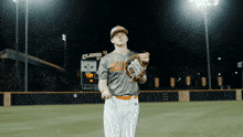 a baseball player stands on a field with a sign that says trust on it