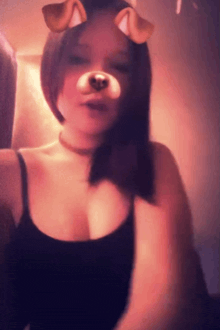 a woman wearing a black tank top and a dog mask