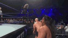 a wrestling match is going on in a ring with the letter t on the side