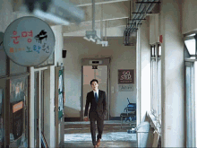 a man walks down a hallway with a sign that says go step
