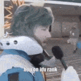 a person wearing a helmet is holding a microphone and saying hop on idv rank .