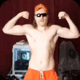 a shirtless man is flexing his muscles in front of a computer .