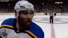 a hockey player wearing a ccm helmet stands on the ice