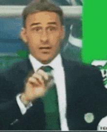 a man in a suit and tie is talking into a microphone ..