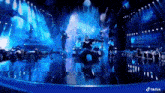 a group of people dancing on a stage with a tiktok logo in the background
