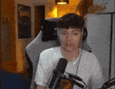 a man wearing headphones is sitting in front of a microphone .
