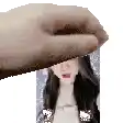 a hand is holding a picture of a woman with long hair .