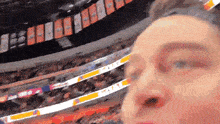 a man is taking a picture of himself in a stadium with a banner that says ' tnt ' on it