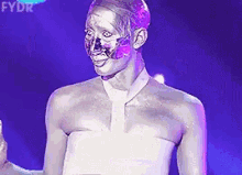 a person with silver paint on their face is standing in front of a purple background with fydr written on it