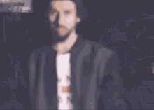 a man with a beard is wearing a white shirt that says mm on it