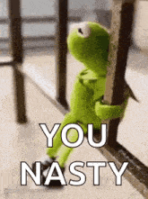 kermit the frog is standing next to a railing and holding a pole .
