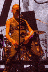 a man in a black jumpsuit is standing in front of a microphone