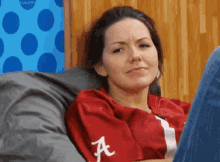 a woman wearing a red shirt with the letter a on it