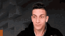 a young man wearing headphones is making a funny face in front of a minecraft background .