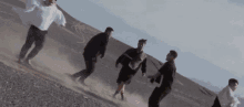a group of people are running on a dirt road .