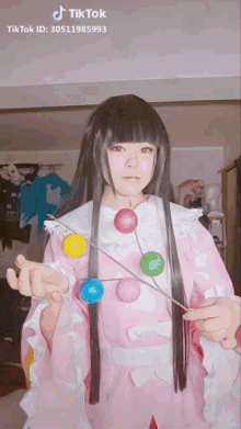 a tiktok video of a girl in a pink dress holding balloons
