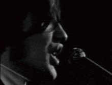 a man singing into a microphone with his mouth open