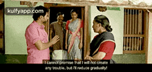 a man in a pink shirt is talking to two women in front of a door ..