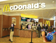 a mcdonald 's restaurant with a bunch of people in front of it