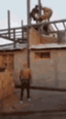 a blurry picture of a man standing in front of a building with a steering wheel .