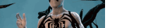 a man with a spider on his chest is giving a peace sign
