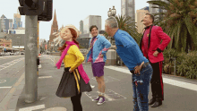 a group of people are standing on a sidewalk in front of a city street