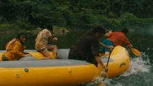 a group of people are in a yellow raft