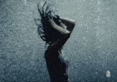 a woman is standing in the rain with her hair flying in the air