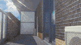 a balcony with a brick wall and a window with the sun shining through it