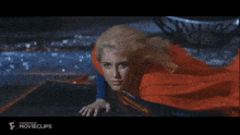 a woman in a superman costume is flying through the air .