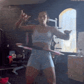 a woman is holding a hula hoop in front of a window with the hashtag #thenextbigthing
