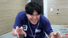 a man wearing a blue shirt that says leo is smiling