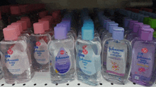 several bottles of johnson 's baby oil are lined up on a store shelf
