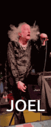 a man smoking a cigarette and singing into a microphone with the name joel written on the bottom