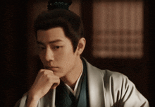 a man with a bun on his head is looking down
