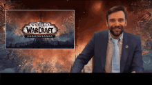 a man in a suit and tie stands in front of a screen that says world of warcraft
