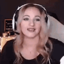 a woman wearing headphones and a microphone is looking at the camera and smiling .