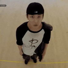 a man wearing a baseball cap and a shirt with a dollar sign on the front