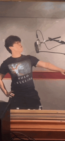 a man wearing a solo eveline t-shirt stands in front of a microphone