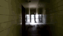 a dark hallway with a light coming out of the end of it
