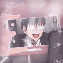 a person is taking a picture of a man with glasses on their phone with picmix on the bottom