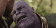 a close up of thanos ' face with his eyes closed and a beard .