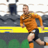 a soccer player wearing an orange jersey with the number 40 on it