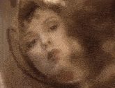 a woman with curly hair is looking at herself in a mirror