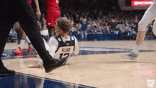 a basketball player with the number 17 on his back is laying on the floor